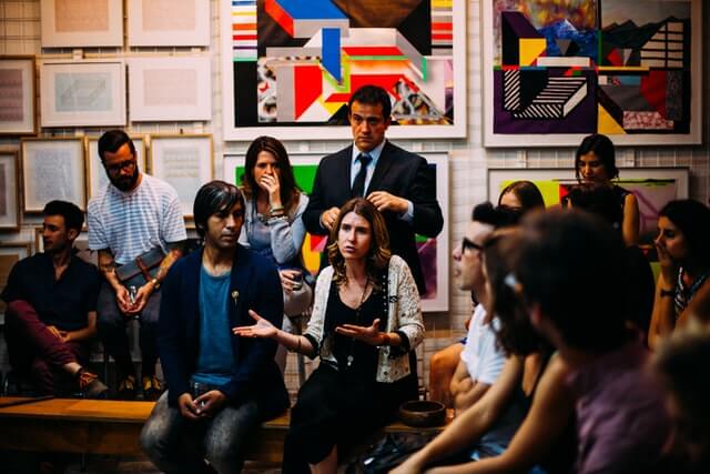 Grupo de pessoas reunidas em um museu e conversando