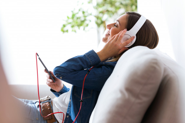 Mulher ouvindo música no fone pelo celular