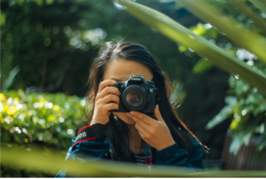 Mulher com câmera fotográfica na mão fotografando